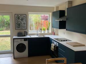 a kitchen with a sink and a washing machine at Comfortable Homestay by Earith Lakes in Earith