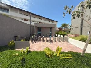 a building with bikes parked in front of it at Beach Class Summer Residence in Porto De Galinhas