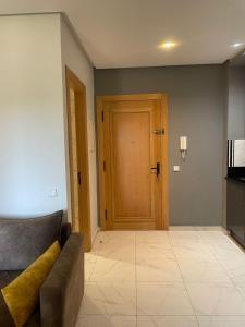 een woonkamer met een bank en een houten deur bij Résidence Picasso in Casablanca +2 foto's