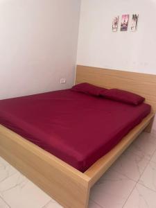 een bed met een houten frame in een kamer bij Résidence Picasso in Casablanca