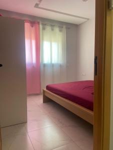 een slaapkamer met een bed en een raam bij Résidence Picasso in Casablanca