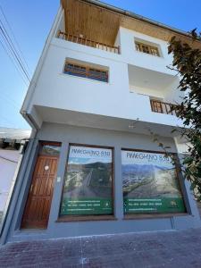 a white building with two posters in front of it at Rosa Mosqueta Esquel in Esquel