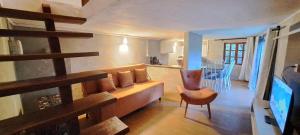 ein Wohnzimmer mit einem Sofa und einem Stuhl sowie eine Küche in der Unterkunft Chalé em Morro de São Paulo in Cayru