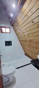 ein Bad mit einem WC und einer Holzwand in der Unterkunft Chalé em Morro de São Paulo in Cayru + 22 Fotos