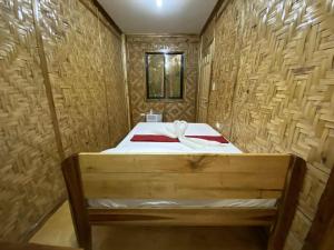 Un dormitorio con una cama en una habitación de madera. en The Tribe Apartment, en Port Barton