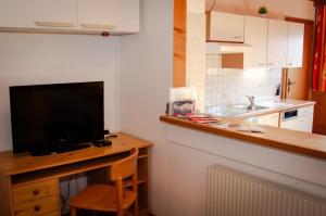 a kitchen with a television and a counter with a desk at Schlickhütte in Grossarl
