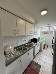 eine Küche mit weißen Schränken und einer Spüle in der Unterkunft Excellent apartment, view and quiet atmosphere in Viña del Mar