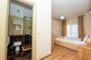 a bedroom with a bed and a bathroom with a sink at Poseidon Nest - 2BR, 360 Sea View, Office in Durrës +68 photos