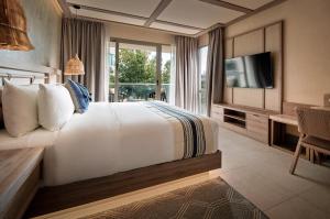 een hotelkamer met een bed en een televisie bij Hotel Indigo Playa del Carmen by IHG in Playa del Carmen