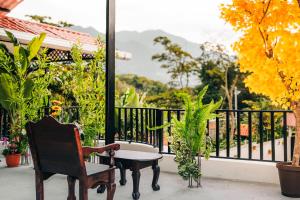 a chair and a table on a balcony with a view at Hotel Villa Luna in San Juan La Laguna