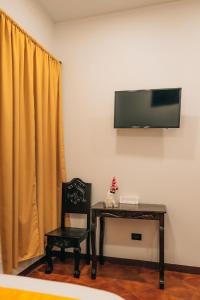 a room with a table and a chair and a television at Hotel Villa Luna in San Juan La Laguna +18 photos