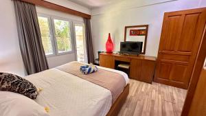 a bedroom with a bed and a desk with a television at Nattaya at the Jayakarta Bali in Seminyak +21 photos