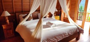 a bedroom with a bed with two towels on it at Kastawa Villa in Sidemen