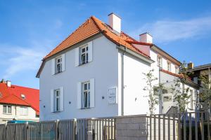 una casa bianca con una recinzione davanti di Villa Baltica Gdańsk a Danzica