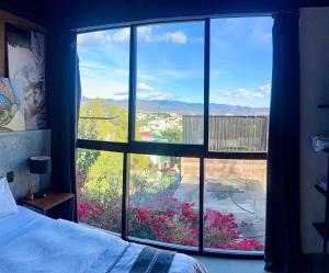 a bedroom with a large window looking out at a garden at Upscale 2BR 2BA Apt w incredible Mountain Views in Oaxaca City