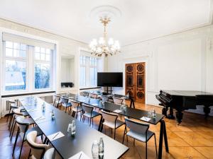 a room with tables and chairs and a piano at TRIBE Riga City Centre in Rīga