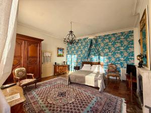 ベレームにあるChâteau des Feugeretsのベッドとシャンデリアのある寝室