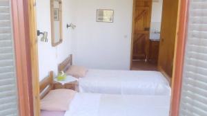 Loutrópolis ThermísにあるApartments Villa Myrtoの小さな部屋のベッド2台(白いシーツ付)