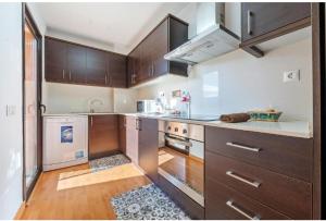 eine große Küche mit Holzschränken und einem Herd in der Unterkunft Apartamentos de Ángel in Vinebre