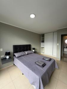 Un dormitorio con una cama grande con una manta morada. en Edif Alarif Piso 7F, en Posadas