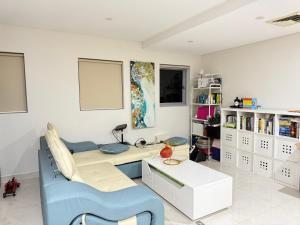 シドニーにあるUrban Silver Haven Sleek stay - 1 Min to Station With TV projector Game space and high speed internetのデスク、ソファ、テーブルが備わる客室です。