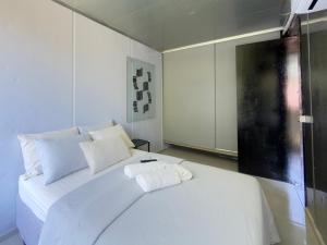 een slaapkamer met een wit bed met twee handdoeken erop bij Casa Container Moderna com Vista da Natureza em Itajaí in Itajaí