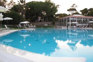 a large blue swimming pool with chairs and umbrellas at Quinta do Lago Golf in Quinta do Lago +34 photos