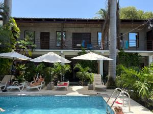una piscina con sedie e ombrelloni accanto a una casa di Dos Palmas a El Sunzal