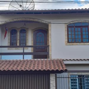 una casa bianca con finestre blu e tetto rosso di Flat luxo e tranquilidade a Volta Redonda