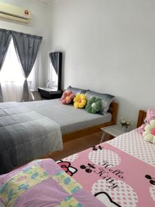 a bedroom with two beds with colorful pillows on it at Bukit Katil Indah Homestay in Melaka +10 photos