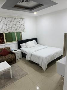 Un dormitorio con una cama grande y un sofá. en ماي سويت, en Kuwait