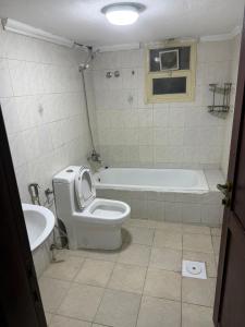 Un baño con bañera, inodoro y lavabo. en ماي سويت, en Kuwait 11 fotos más