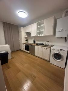 Una cocina con gabinetes blancos y lavadora. en Stylish Apartment near Airport, en Schwechat