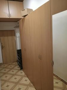 een lege keuken met houten kasten in een kamer bij Centrum Czeski Cieszyn in Karviná +1 foto