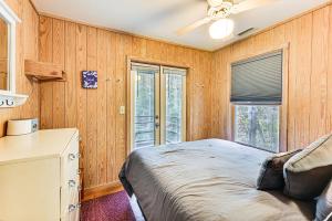 een slaapkamer met houten wanden, een bed en een raam bij Relax Creekside Forest-View Gem in Marietta! in Riverview