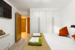 a bedroom with a white bed and a television at Khayat Homes - The Ford in Chelmsford