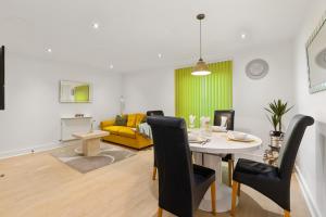 a living room with a table and a yellow couch at Khayat Homes - The Ford in Chelmsford