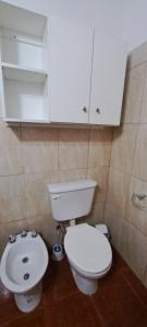 a bathroom with a white toilet and a sink at Casa Tierra in San Antonio Oeste