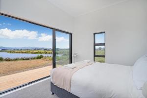 En eller flere senge i et værelse på Lakeside Retreat Matarangi