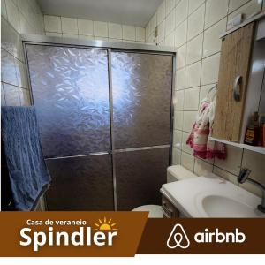 a bathroom with a shower with a toilet and a sink at Spindler summer house in Tramandaí +22 photos