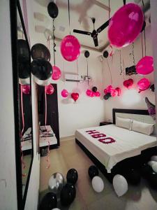 ein Schlafzimmer mit einem Bett, das mit rosa und schwarzen Luftballons geschmückt ist in der Unterkunft Hotel heaven inn in Amritsar