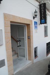 a door in the side of a building with stairs at Hostal El Mirador in Vejer de la Frontera