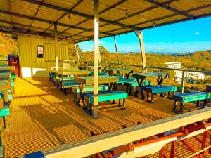 un grupo de mesas y bancos sobre una cubierta en Pupa House Hotel, en Tamarindo 17 fotos más