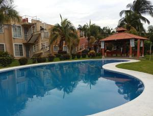 a swimming pool at a resort with a gazebo at Departamento Morrocoy Ixtapa in Ixtapa