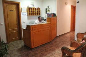 un hombre sentado en una caja registradora en una habitación en Hostal El Mirador, en Vejer de la Frontera