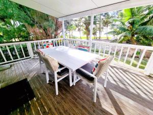 een witte tafel en stoelen op een houten terras bij Natura Nikao Beachside 3BM Villa in Avarua