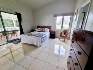 een slaapkamer met een bed en een tafel in een kamer bij Natura Nikao Beachside 3BM Villa in Avarua