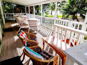 een veranda met stoelen en een tafel bij Natura Nikao Beachside 3BM Villa in Avarua
