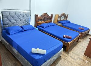 Dos camas en una habitación con sábanas azules. en Hotel 7, en Cúcuta