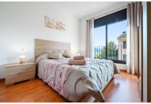 a bedroom with a large bed and a large window at Apartamentos de Miguel in Vinebre